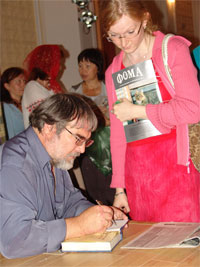 Фото, писатель Максим Яковлев подписывает свои книги