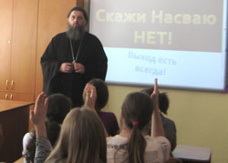 Фото, Владивосток. Руководитель Душепопечительского центра по реабилитации нарко- и алкоголезависимых при Покровском кафедральном соборе протоиерей Александр Талько выступает перед старшеклассниками средней школы № 50