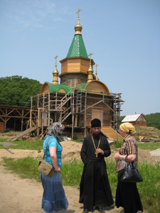 Фото, строящийся монастырский храм свт. Николая. Настоятель игумен Василий беседует с паломниками