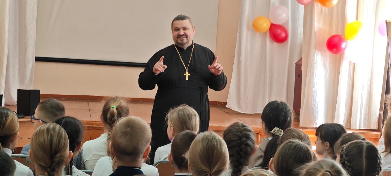 Священник поводит пасхальные беседы со школьниками.